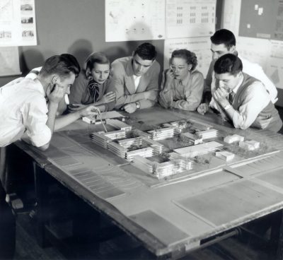 Architecture students discussing a model for women's campus, 1952