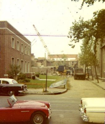 West side of 200 block of South McAlpin Street, 1961, showing the 3600 block of Locust Street in the foreground, the new Delta Phi fraternity house at 3627 Locust Street at the left margin, and the Annenberg School under construction in the background. Delta Phi (St. Elmo), established in 1849, is the University's oldest fraternity. It had owned a house at 3453 Woodland Avenue, but the University acquired that property for the construction of the new Van Pelt Library and offered the site at 3625-29 Locust Street as suitable for relocation. The cornerstone of the new building (just above the white roof of the parked car at the left margin) reads "Delta Phi 1849/1959."
